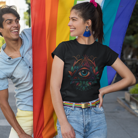 Two people standing in front of a rainbow flag, one wearing a black t-shirt with a colorful design.