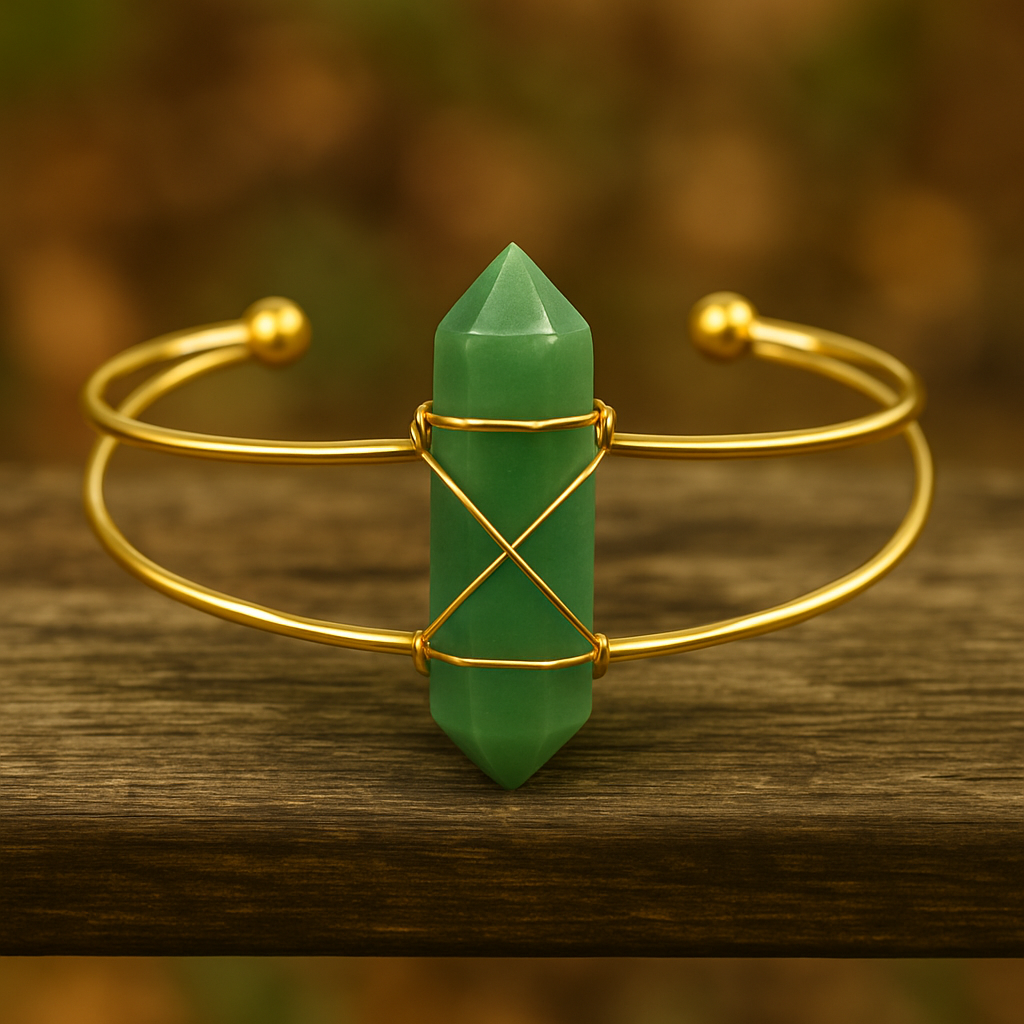 Gold bracelet with a green crystal on a wooden surface