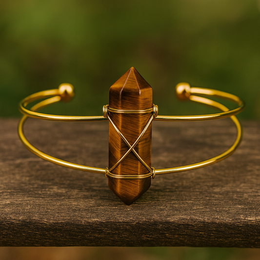 Gold bracelet with a tiger's eye crystal on a wooden surface